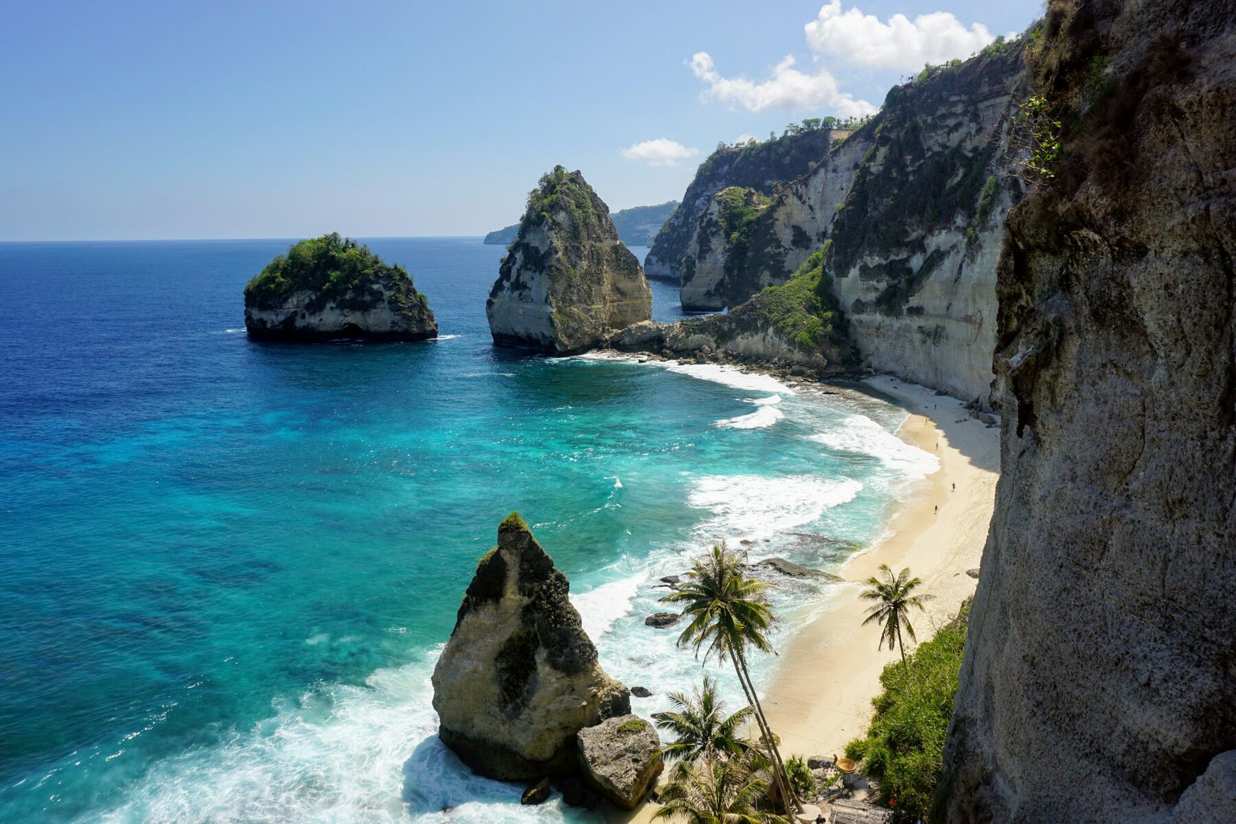 Una playa de Bali con rocas y árboles al borde del agua