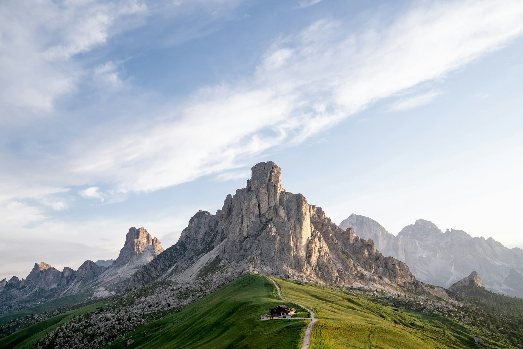 Un prado verde a los pies de una pared de roca en los Dolomitas