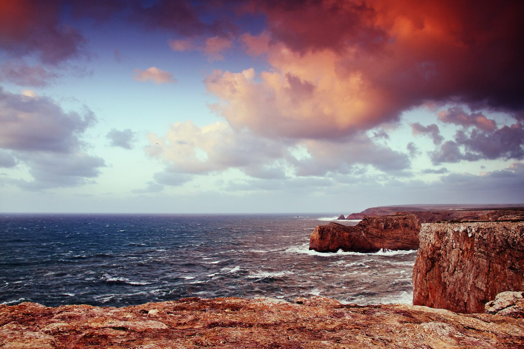 Acantilados de roca cayendo a plomo sobre el mar en la costa del Algarve